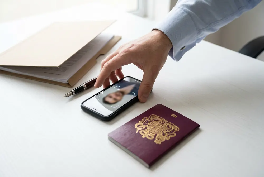 Passport beside a phone showing a face verification frame